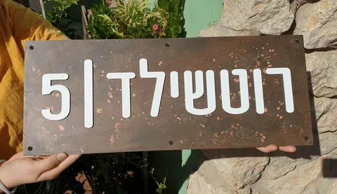 שלט נחושת עם אותיות לבנות